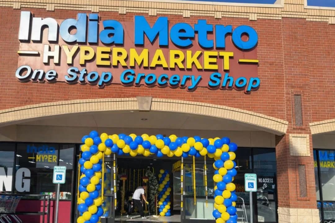Blue and yellow balloon arch framing the entrance of India Metro Hypermarket beneath the store sign