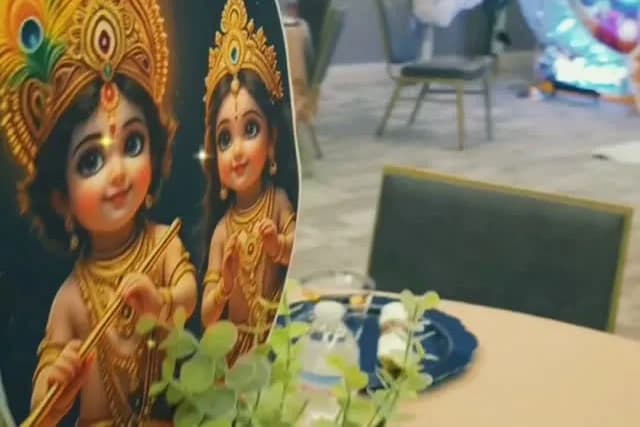 Round baby shower panel illustrated with young Radha and Krishna, with blue and white flowers at its base